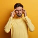 Man met stress en overprikkeling die spanning in het hoofd ervaart